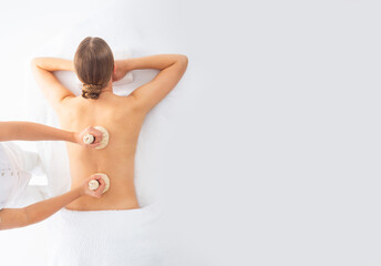 Obraz premium Young woman getting massaging treatment over white. Spa, healthcare and recreation concept.