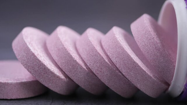 Pink Effervescent Tablets Spilling from a Container
