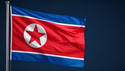 Realistic image of the North Korean national flag waving on a flagpole against a dark blue background.