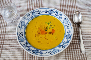 Creamy carrot soup with oil, herb and chilli.