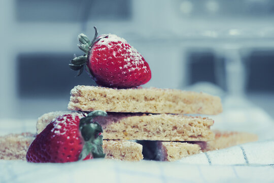 Close-up of a stack of Shortbread biscuits with fresh strawberries