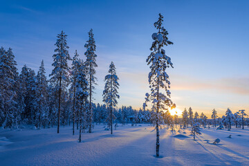 Landschaft im Winter mit Sonnenuntergang und Wald in &Auml;k&auml;slompolo, Finnland