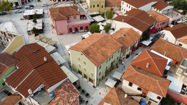 Cinematic aerial view of Vlor&euml;, Albania from Justin Godard Street, showing the city layout, nearby coastline, and bright sunny weather