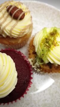 Top Down Video of a Trio of Decorated Cupcakes with Different Flavors and Toppings, Vertical Video