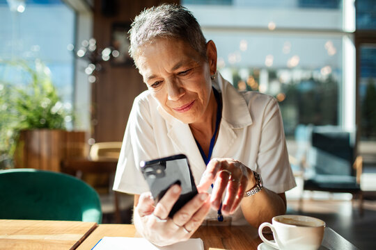 Mature professional using smartphone in a cafe
