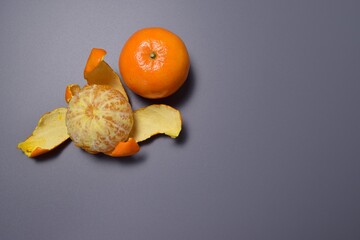 Two ripe juicy tangerines on a gray background