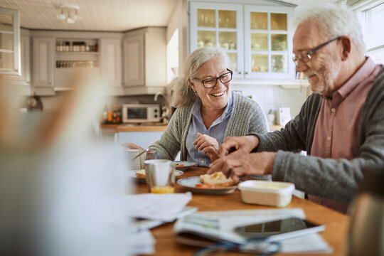 Happy senior couple having breakfast in a home kitchen