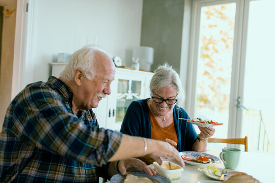 Smiling senior couple preparing lunch at home