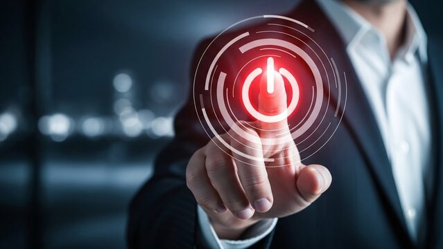 Businessman's finger touches a glowing red power button icon, symbolizing initiation and launch.