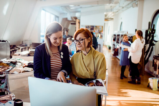 Two women reviewing designs in a fashion studio