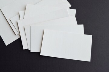 A close-up of a stack of blank cards scattered against a black background