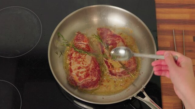 Beef steaks searing in hot pan, close up view.