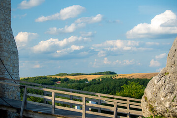 Fototapeta premium medieval castle bridge overlooking green hills and summer sky