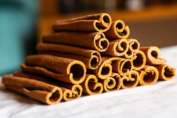 Cinnamon cassia sticks stacked together, showcasing their rich brown color and curled ends. Ideal...