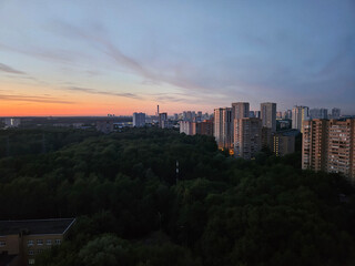 City skyline with a beautiful sunset in the background. The sky is filled with clouds and the sun is setting