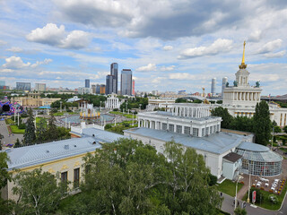 City with a large building in the middle. The building has a dome on top. There are many trees in the area. VDNH Moscow - exhibition of achievements of the national economy