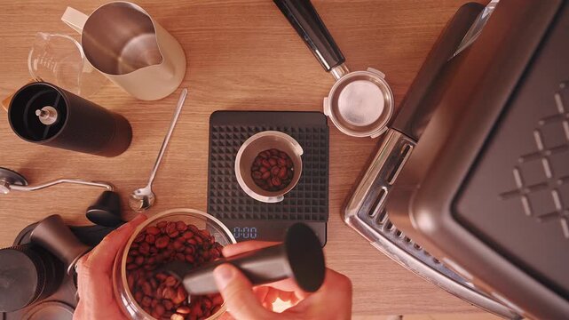Man measuring Coffee Bean on digital scale at 18 gram during Espresso Preparation, Top View with Warm Light and Slow Motion showing precise barista hand workflow