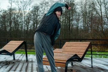 Fototapeta premium A woman performing side stretches during her outdoor workout routine. Emphasizing the importance of flexibility and mobility for overall physical health and activity.