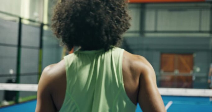 Man, back view and playing with padel for sport competition, match or indoor game together. Active, male people or tennis players with swing, hit or bat in court for fitness, training or practice