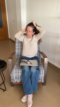 Mujer recogi&eacute;ndose el cabello en un mo&ntilde;o improvisado con un bol&iacute;grafo