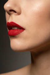 Close up profile of a woman's face showing her perfect red lips and flawless skin.