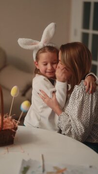Happy Mother and Daughter Celebrate Easter with Hugs and Kisses While Wearing Bunny Ears