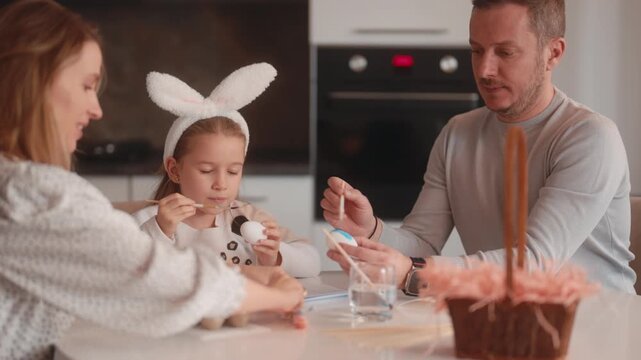 Happy Family Decorating Easter Eggs Together in Their Cozy Kitchen