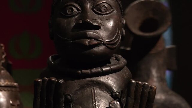 An ethnic art display featuring African masks, sculpted busts, and statuettes from Central Africa. These ritual and cultural objects showcase traditional craftsmanship.