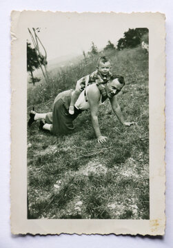 FOTOGRAFIA ANTICA CON UN PADRE E UN PICCOLO FIGLIO GIOCANDO SUL PRATO