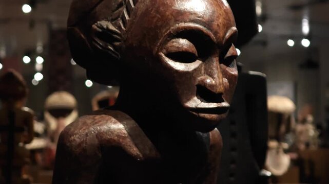 An exhibition showcasing Central African art: ritual masks, wooden sculptures, busts, and figurines representing the cultural heritage and ethnic style of the continent.