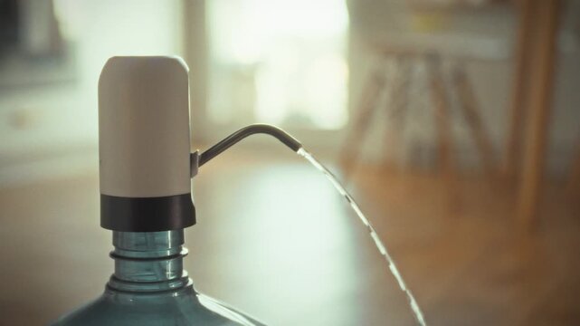 An electronic water dispensing machine effortlessly pumps drinking water from large home bottle, regulating flow maintaining optimal water pressure for smooth consumption, making hydration convenient