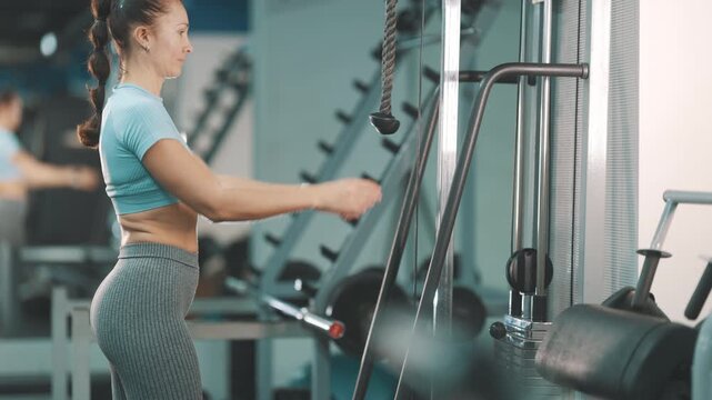 Athletic woman doing triceps pushdown exercise