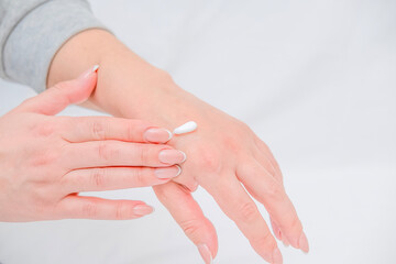 Fototapeta premium Female hands applying cream to hand