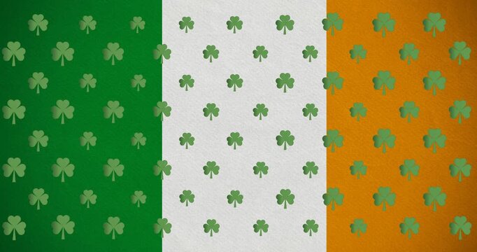 Digital animation of multiple clover leaves moving against irish flag