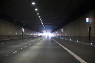 Driving towards the bright exit of a tunnel