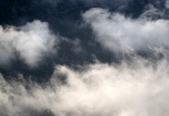 Obraz premium Beautiful landscape with mountains among fog and clouds at sunset.