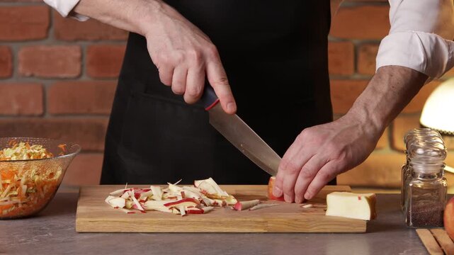 The cook stirs the tomato, cabbage and corn salad in a bowl with a spoon.