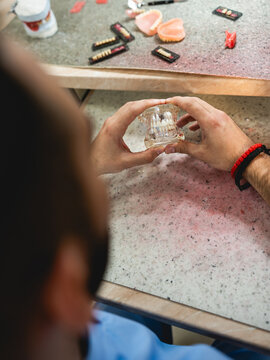 A dental technician creates a denture model in a dental office.