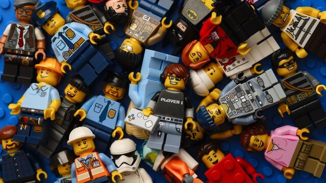 Tambov, Russian Federation - February 02, 2026 Heap of Lego minifigures on blue baseplate.