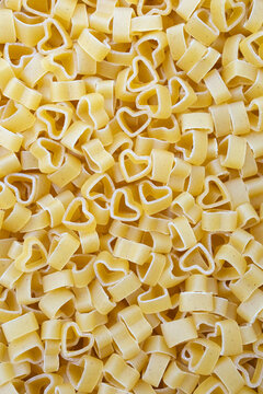 Сlose-up of heart-shaped pasta. Vertical food banner. Selective focus, top view