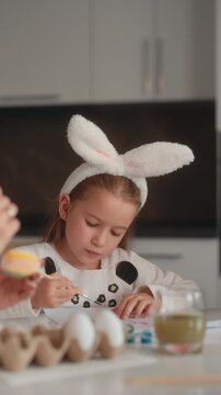 Little Girl With Bunny Ears Painting Easter Eggs At Home
