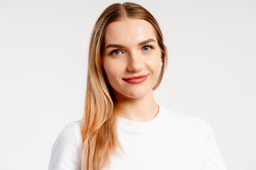 Obraz premium Young woman smiling while looking at camera on white background