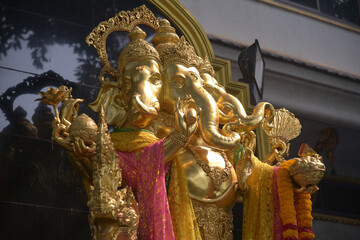 A statue of the three-headed Ganesha is placed outdoors for Buddhists and tourists to worship at Wat Pariwat Ratchasongkhram temple in Bangkok capital city in Thailand.