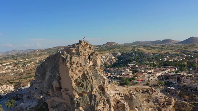 Aerial view of Uchisar Fortress and the surrounding town in Cappadocia, Turkey, showing the regions iconic rock formations.
