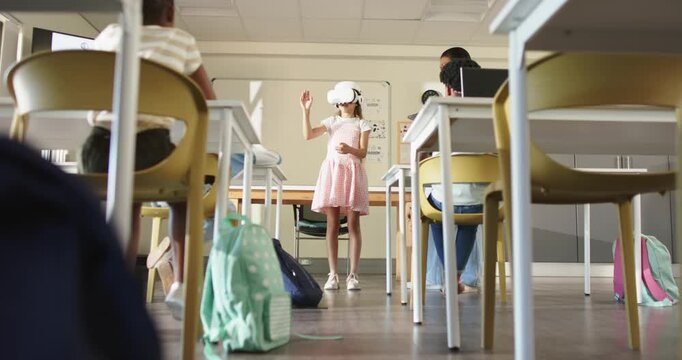 VR headset activating, child reaching in center aisle and demonstrating in VR, classmates watching