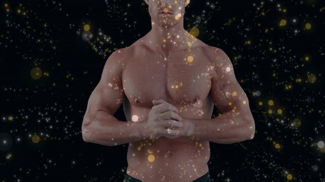 Camera revealing upper body male standing clasping hands particles crossing torso showing fitness