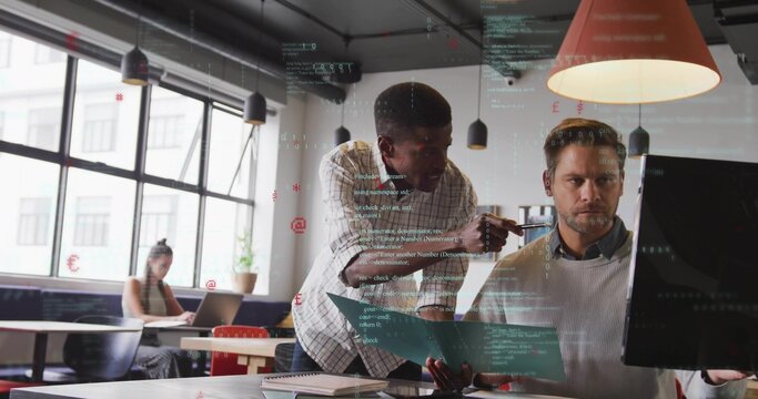 Leaning men pointing at widescreen monitor in open plan office in checked shirt with blue folder