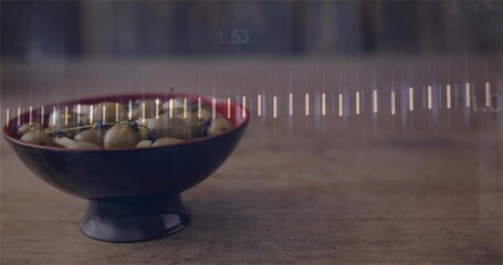 Displaying footed bowl with red rim holding olives on wood tabletop, showing waveform overlay © vectorfusionart