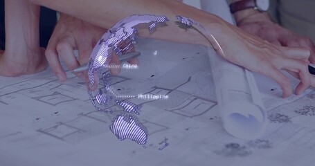 Obraz premium Pointing two hands in rolled sleeves tracing plans on studio table, with rolled plan, digital globe