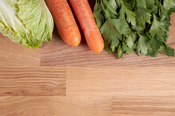 Ingredients for making salad, cabbage, carrots and parsley on a cutting board.